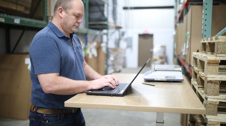 man in blue polo shirt using laptop computer